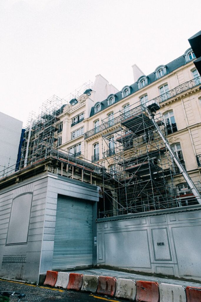 A historic building with scaffolding undergoing renovation in an urban area.